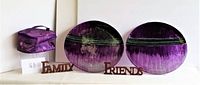 Two round glass platters displayed with three purple sequined zippered cosmetic bags each with mirrors, nesting inside each other