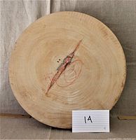 Top view of circular tamarind wood cutting board showing wood grain, central crack with red markings, numbered card '14' for reference.