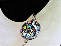 Front angle of bracelet showing The Bear design in colorful abstract style on round charm attached to silver-tone metal band