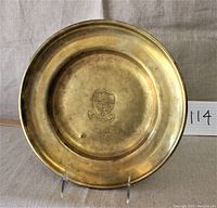 Full view front of the brass tray showing entire shape and embossed crest.