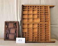 Two wooden typecase trays side by side, smaller tray contains vintage wooden printing type.