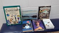 Six books arranged showing front covers including Players of Cooperstown, British Columbia, Harrowsmith Reader, Anne Murray biography, Willie Nelson autobiography, and Critical Care by Phillip Brown