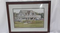 Front view of the framed golf course clubhouse artwork showing the full piece including frame and matting.