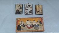 Three framed Japanese style art pieces displayed together plus the carrying cover with sumo wrestlers on cover.