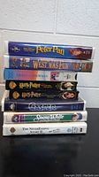 Stack of 8 VHS movie tapes showing titles including Peter Pan, How the West Was Fun, Frosty the Snowman, and two Harry Potter movies at the top.