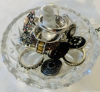 Clear photo of vintage crystal ring holder with nine assorted ladies rings placed around the central cone.