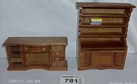 Wide shot of the miniature wooden dollhouse bookcase and desk set showing the full pieces side by side.