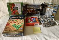 Three boxed puzzles including Keepsakes 500-piece Christmas tree, Mandalas color puzzle, and Creates 500-piece street scene puzzle, plus Chinese Checkers boxed game and a bag of puzzle pieces.