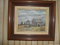 Framed oil painting showing rustic barn and cows under cloudy sky