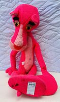 Front view of large vintage Pink Panther stuffed animal sitting upright showing facial features, body, and tail.