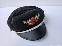 Black Harley Davidson captain hat with embroidered logo and white rope accent shown from an angle