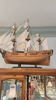 Front view of full ship model showing hull, sails, rigging and wood base