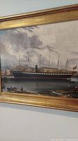 Photo showing the left side of the framed print depicting a large sailing ship and part of the waterfront with people.