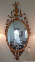 Front view of oval mirror showing full frame and reflection