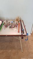 Overview of lot items on table including candle sconces, scissors, bolo cords, horse crop, and sword