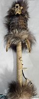 Front view of Halloween decor showing animal skull, fur, feather details, and wrapped handle