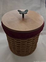 Front view of Longaberger round canister basket with lid and butterfly knob.