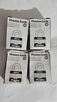 Four unopened Master Lock commercial padlocks in original boxes