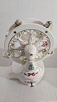 Top angled view of white porcelain Ferris wheel showing children figures and ornate design