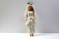 Front view of 12-inch Barbie doll in white satin dress with lace and veil.