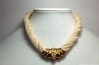 Full view of the choker length twisted faux pearl necklace shown on a mannequin, featuring the gold tone centerpiece with rhinestones.