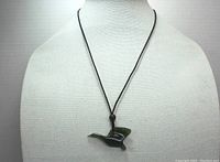 Full view of the necklace on a mannequin bust, showing green jade Canada goose pendant and black cord.