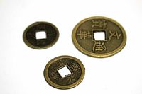 Top-down view of three round coins with square center holes: one large and two smaller ones with visible Mandarin characters.