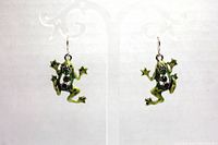 Both silver-toned green frog earrings with rhinestones shown hanging on clear earring display stand against white background.