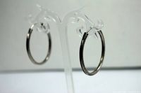 Side view of one sterling silver oval hoop earring on display stand showing shape and clasp closure.