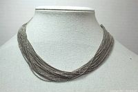 Front view of silver-toned multi-chain necklace displayed on a mannequin bust, showing the intertwined 22 chains and metal bar ends.