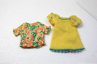 Yellow puff sleeve dress and floral jacket laid flat showing front sides.