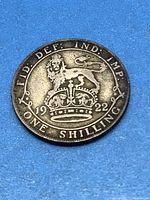 Obverse side of the coin showing crowned lion and date 1922, text 'FID DEF IND IMP ONE SHILLING'.