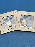 Front and back of two 5 cents Newfoundland coins in holders showing the year and denomination.