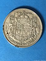Reverse side of 1946 Canadian fifty cents silver coin showing Canadian national coat of arms, denomination, and date.