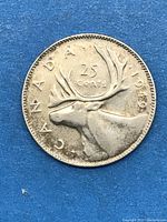 Reverse side of silver Canadian 25 cent coin dated 1949 showing caribou design and denomination.