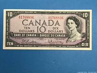 Front side of 1954 Canadian $10 banknote showing Queen Elizabeth II portrait and red serial numbers.