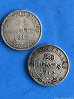 Obverse sides of 1917 25 cents and 1912 20 cents Newfoundland silver coins showing denomination, year, and decorative flourishes.
