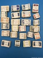Bundles of Canadian used postage stamps tied together with paper bands and labeled with catalog numbers and dates from 1952 to 1967.