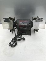 Full view of black Craftsman bench grinder showing two grinding wheels, tool rests, and power cord.