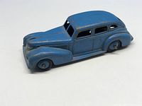 Side view showing the blue Chrysler diecast car with paint wear and original wheels.