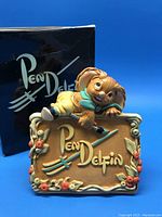Front view of the Pendelfin Golden Jubilee figurine with box. Shows the detailed rabbit character lying on Pendelfin plaque.