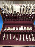 Full view of the silverplate flatware set arranged in the velvet-lined wood case, showing all pieces and the interior lid with Rogers Bros branding.