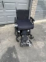 Front view showing seat cushion, footrest assembly folded and joystick control on right armrest