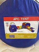Photo of the product packaging showing a colorful 4 piece kids play tent set including a teepee, tunnel, and cube. Fabric is 190T polyester.