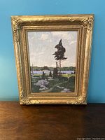 Full view of framed oil painting showing lakeside landscape by Lorne K. Smith