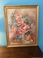 Framed vintage oil painting depicting a cluster of pink and peach English roses with green leaves on a muted background, signed by Eva Hinding.