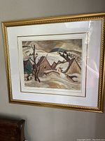 Framed print showing a winter landscape with houses covered in snow, attributed to A.Y. Jackson of the Group of Seven.