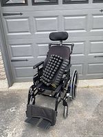 Front-left view of wheelchair with Roho cushion on seat, headrest and footrests visible