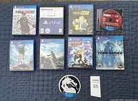 PlayStation 4 games including cases and discs arranged on blue background.