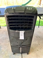 Front view of black NewAir portable AC unit showing louvers and caster wheels